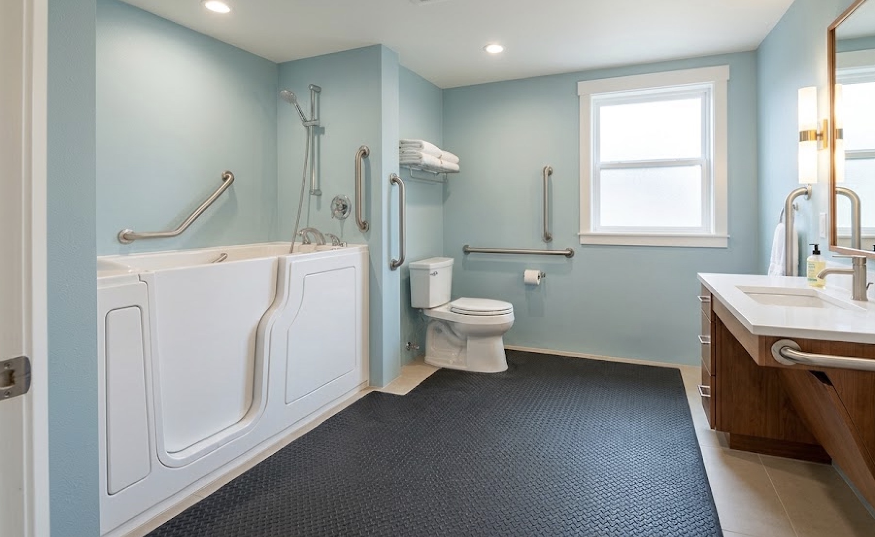 Accessible Colorado Springs bathroom with a walk-in tub, grab bars, comfort-height toilet, and roll-under vanity