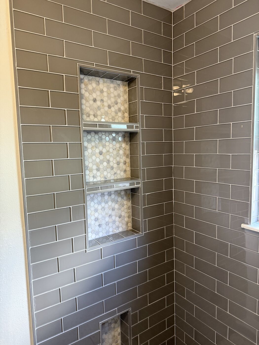 Finished gray subway tile shower with a mosaic niche from a Colorado Springs bathroom remodel