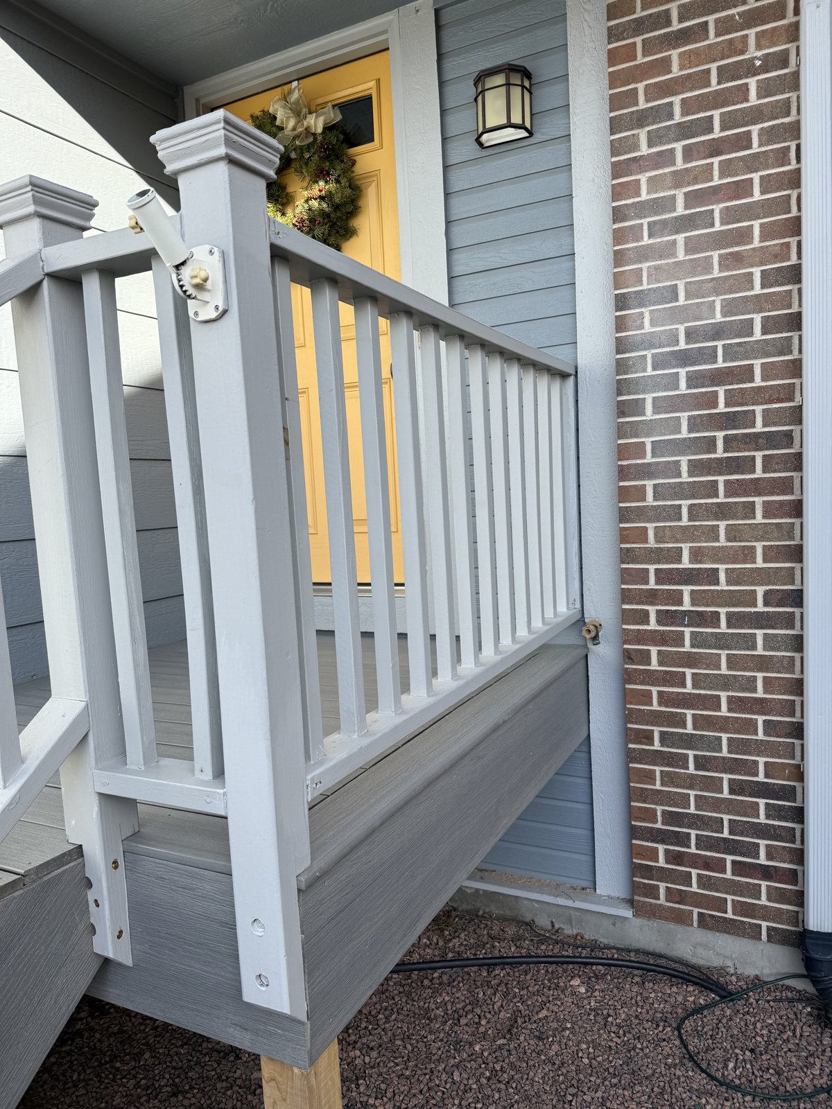 Close view of a new painted deck railing and post cap on a composite front entry deck