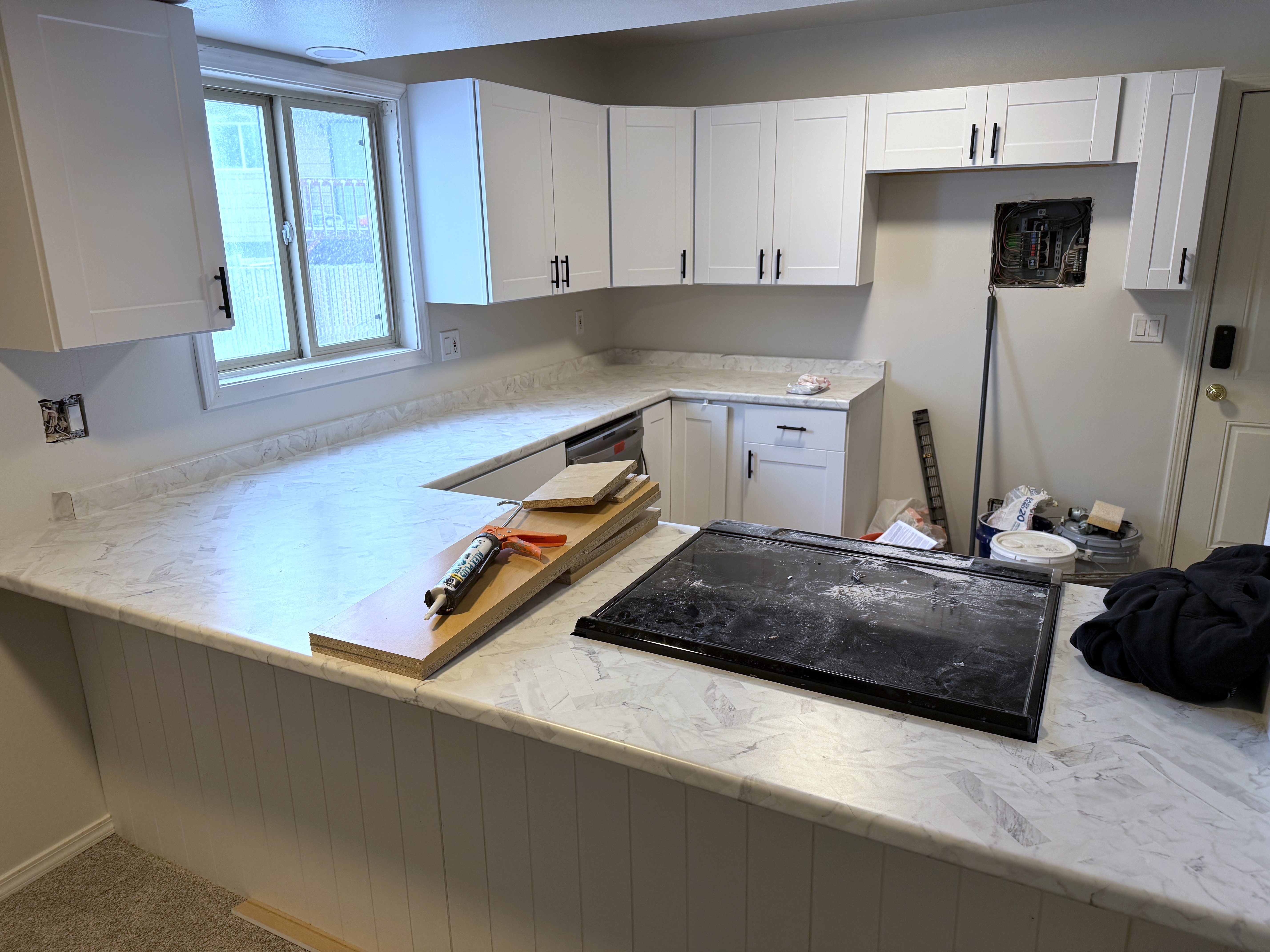 Kitchen remodel in progress with new white shaker cabinets and marble-look countertops in a Colorado Springs home