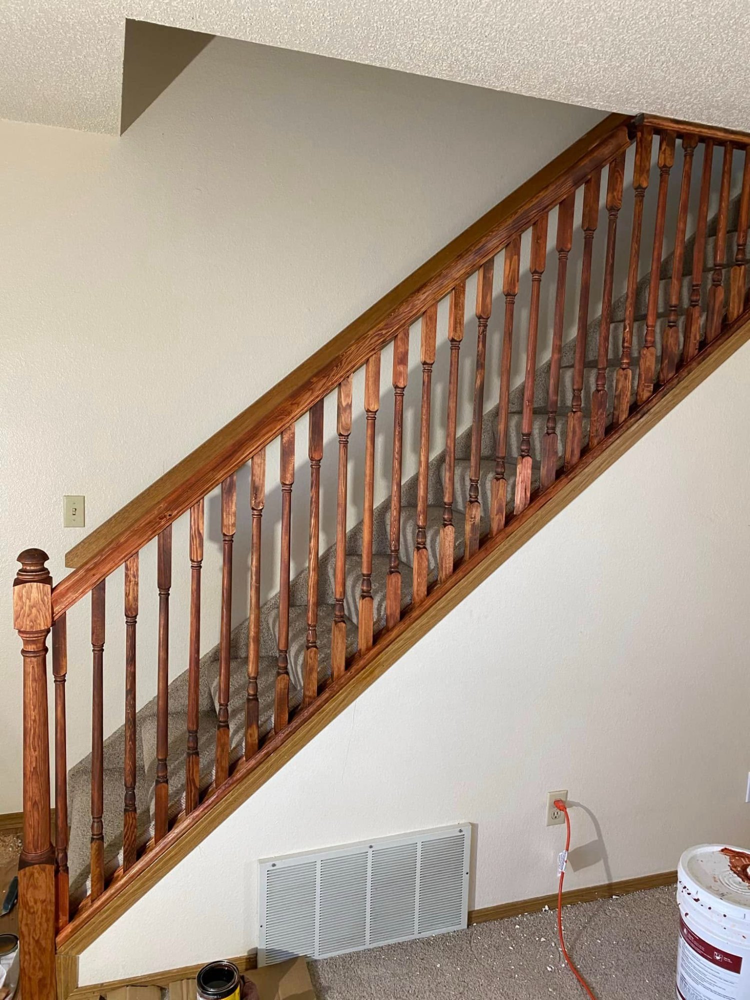 Freshly stained oak stair railing with turned balusters in a Colorado Springs townhome
