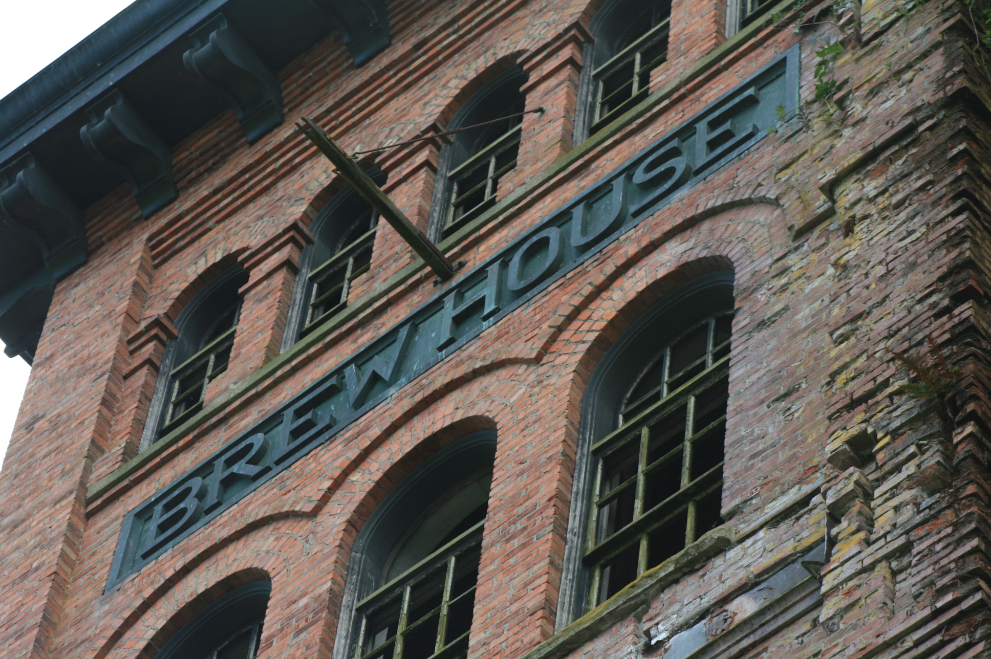The 1906 Olympia Brewery brewhouse tower in Tumwater, Washington — moss-covered brick, arched windows, and the word BREW HOUSE carved into the facade
