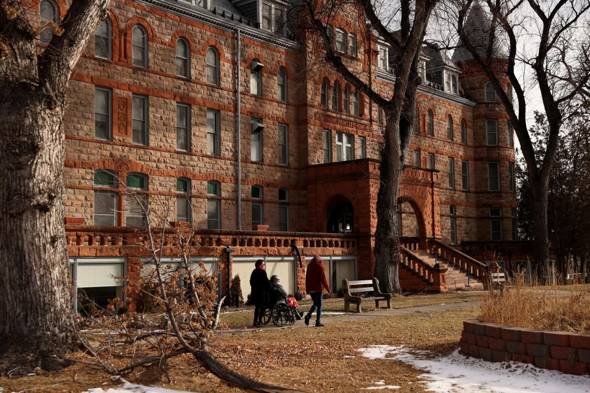 People walking in front of the Union Printers Home main facade in winter light