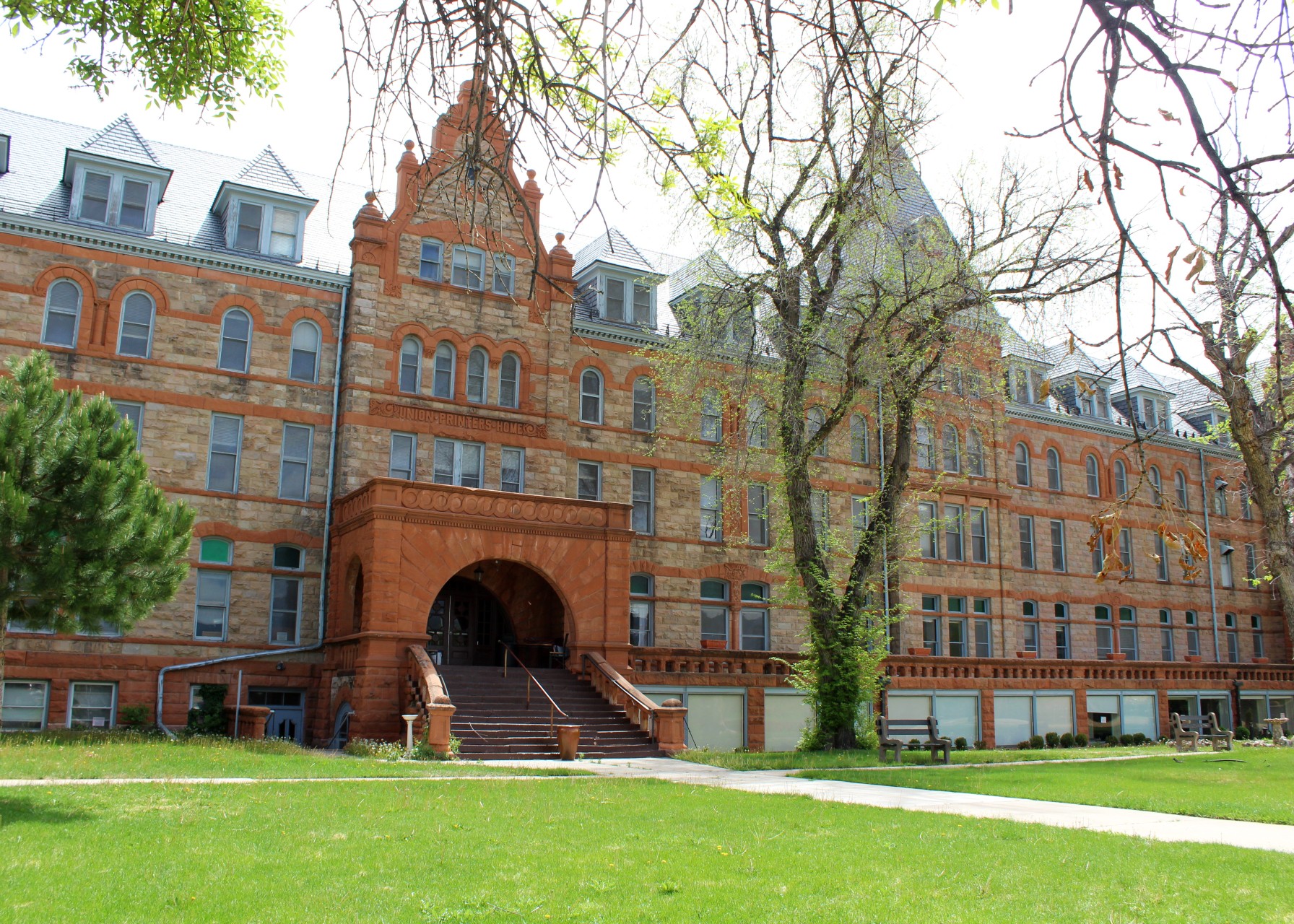 The Union Printers Home campus from the lawn in summer, full building and clock tower visible